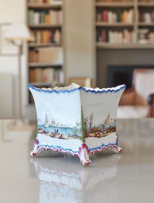 a vase that is sitting on a table with a book shelf in the background