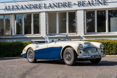a blue and white sports car parked in front of a building