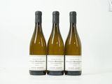 trois bouteilles de vin blanc posées les unes à côté des autres sur une table