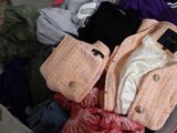 une valise pleine de vêtements posée par terre
