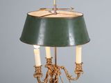 une lampe posée sur une table, avec un abat-jour vert