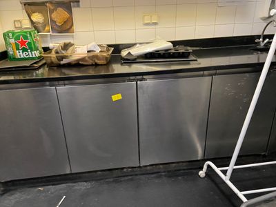 une cuisine avec des placards en inox et un plan de travail noir
