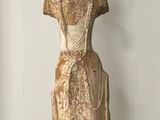 statue of a woman in a dress standing on a black base