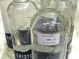 quatre bouteilles de vodka sont alignées sur une nappe blanche