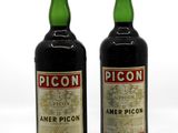 deux bouteilles d'alcool posées l'une à côté de l'autre sur une surface blanche