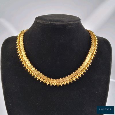 un collier en or sur un mannequin sur fond blanc