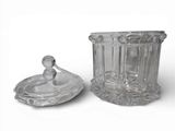 a glass container with a lid sitting next to a glass container