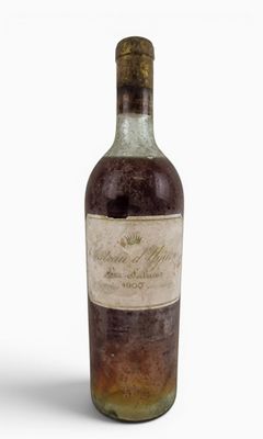 an old bottle of wine sitting on top of a white surface