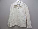 a white jacket hanging on a hanger on a wall