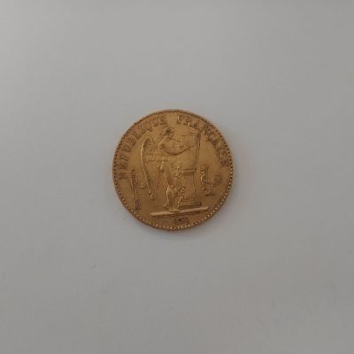 gros plan d'une pièce d'or sur une surface blanche