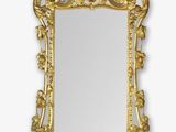 an ornate gold mirror with a bird and flower decoration