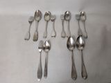 six spoons and six forks laid out on a table