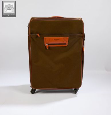 La valise marron et orange est posée sur une surface blanche.
