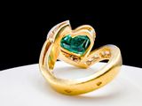 yellow gold ring with a heart shaped emerald surrounded by diamonds
