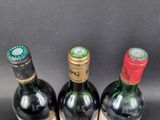 three bottles of wine sitting on top of a table next to each other