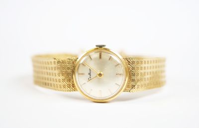 une image d'un gros plan d'une montre-bracelet sur une surface blanche