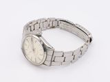 a silver watch that is sitting on a white surface