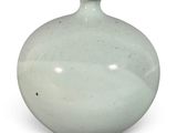 un vase blanc posé sur une surface blanche