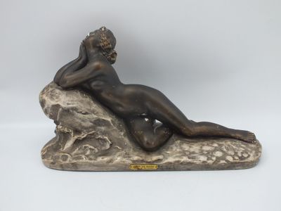 une image représentant une statue d'une femme allongée sur un rocher