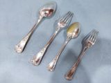 four silver spoons and two silver spoons on a table