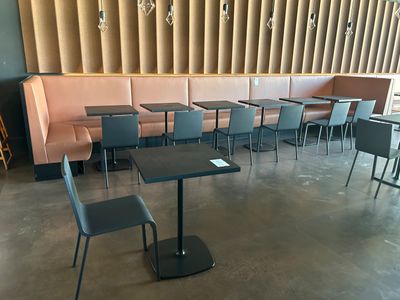 de nombreuses tables et chaises dans un restaurant, avec un mur derrière elles