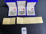 a couple of silver coins sitting in a blue box on top of a table