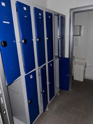 Plusieurs casiers bleus sont alignés les uns à côté des autres dans une salle de bains.