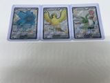three pokemon cards are sitting on top of each other