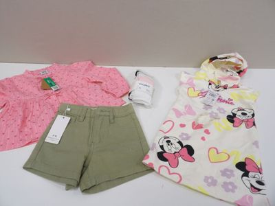 a baby girl ' s clothing set on a white table