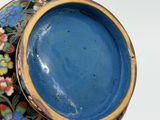 a close up of a blue vase with flowers on it