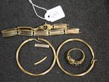 two gold rings and a bracelet are on a black surface