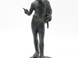bronze statue of a man with a backpack on a white background