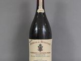 une vieille bouteille de vin posée sur une table en verre