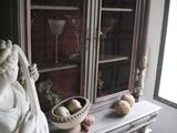 a statue of a woman holding a basket on top of a cabinet