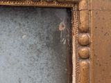 an image of a gold framed mirror on a wall in a room