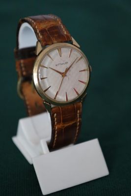 une montre posée sur un support sur une table