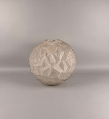 un vase blanc posé sur une surface blanche