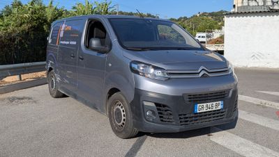 une camionnette Citroën garée sur le bord de la route, devant un immeuble