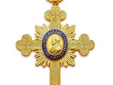 une croix en or sur laquelle est accrochée une médaille bleue et dorée