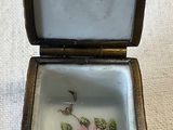 a small box with a flower on it on a table