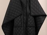 un manteau noir sur un mannequin sur fond blanc