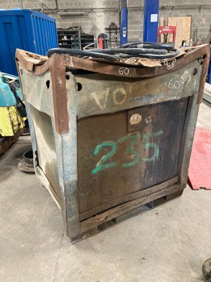 a metal box with graffiti on it in a warehouse
