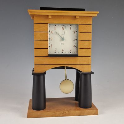 a wooden clock that is on a stand with a pendulum