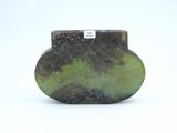 a picture of a green and black vase on a white surface
