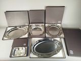 six silver trays in a box on a table