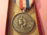 une médaille dans une boîte, entourée d'un ruban