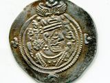 une vieille pièce d'argent sur laquelle figure une couronne, sur un fond blanc