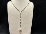 a white mannequin necklace with a cross on it