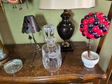 a table with a lamp, a vase, and a vase on it