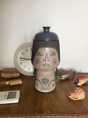 un vase posé sur une table à côté d'une horloge